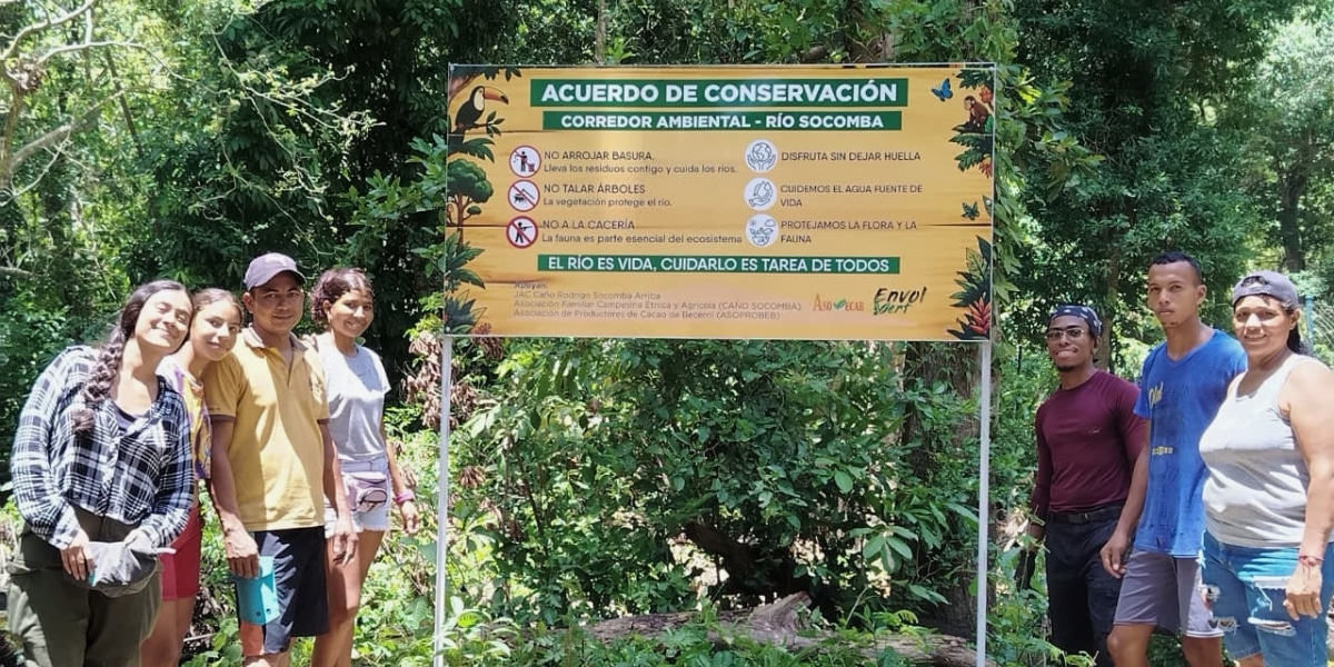 Community members pose with the awareness sign they just put up