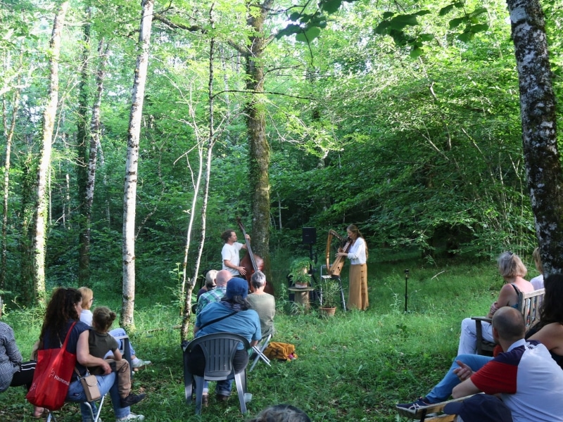 a pair of musicians at the foot of a tree